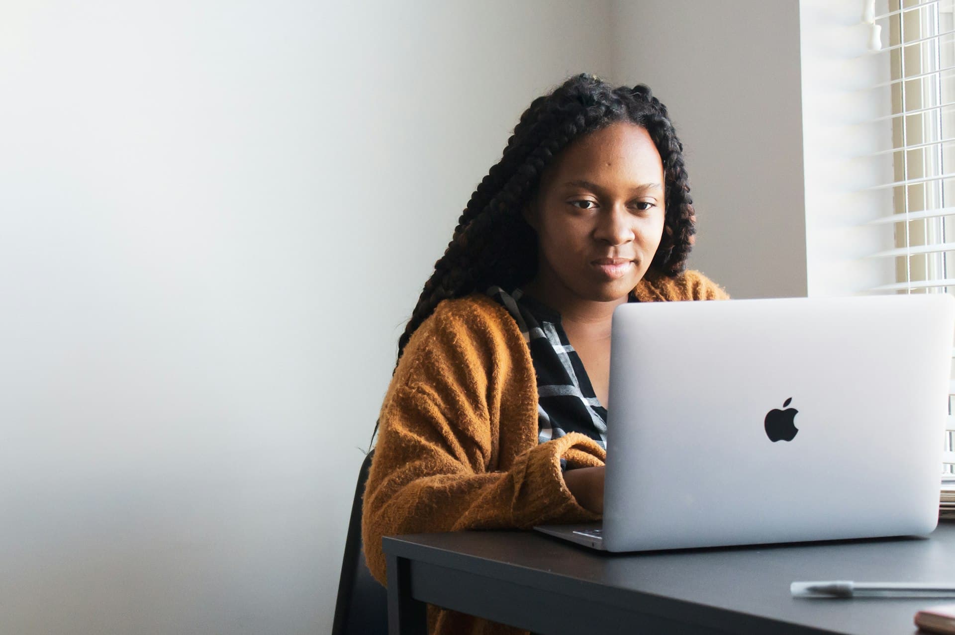 Woman with long braids studying on a laptop