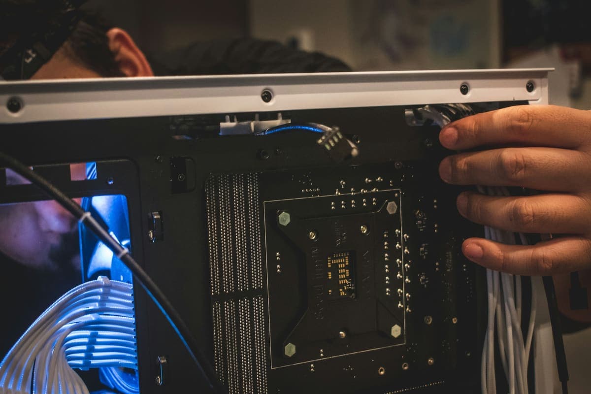 Hands working on cabling inside network equipment