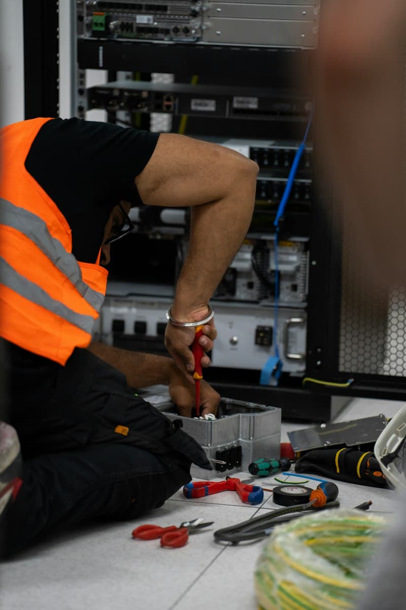 Technician working on network equipment in a server rack